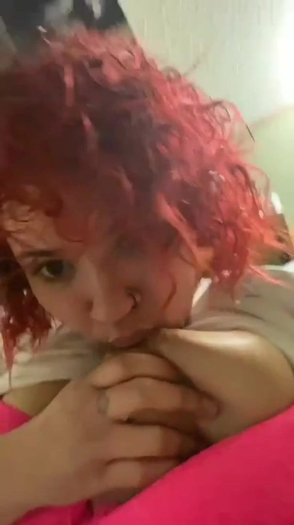 Busty redhead sucking her own titty